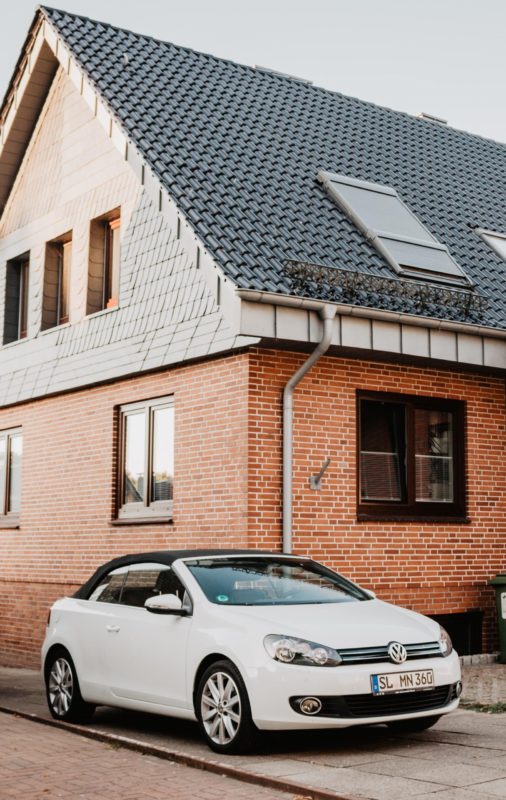 Brick house with white BMW coup parked in front